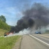 Une voiture en feu sur les lieux d'un accident.