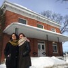 Les deux dames sourient devant le presbytère