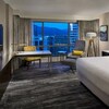 Une chambre à l'Hôtel Hyatt Regency, de Vancouver, avec un lit double, une télévision, une table et un fauteuil.