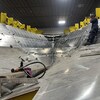 Un travailleur dans une charpente de bateau en construction. 