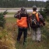 Deux chasseurs à l'orée d'un bois observe une étendue ouverte.                       