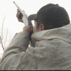Un chasseur autochtone pointe des oiseaux migrateurs avec son fusil de chasse.