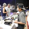 Un cuisinier a une casserole à la main, alors que des gens emplissent leur assiette, au Centre culturel franco-manitobain.