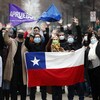 Des gens agitent des drapeaux du Chili et des banderoles en faveur de la nouvelle Constitution.