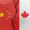 Les drapeaux de la Chine et du Canada imprimés sur une dalle de béton fissurée.