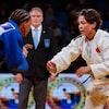 Deux athlètes de judo se regardent pendant un combat, les bras en avant.