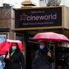 Des gens marchent devant une salle de cinéma de Cineworld.