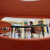 Des enfants dans une garderie vus à travers une ouverture dans le dossier d'une chaise.