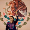 Claudia Sheinbaum est devant un drapeau du Mexique, un poing en l'air.