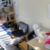Une infirmière est assise devant son ordinateur avec des tests de dépistage de la COVID à sa droite.