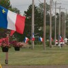Multiples drapeaux de l'Acadie en bordure d'une route.