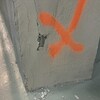 Un X orange sur une colonne grise abîmée.