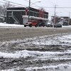 Des voitures circulent dans plusieurs centimètres de neige accumulés au sol.