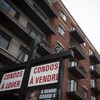 Pancarte indiquant des condos à vendre et à louer devant un immeuble d'habitation.