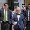 Un groupe d'hommes et de femmes marchant dans un corridor.