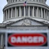 Le Capitole à Washington avec à l'avant-plan, un peu flou, un avertissement de «Danger».