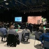Des dizaines de personnes écoutent une conférence sur la foresterie dans une salle de congrès.