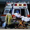Un homme en civière devant une ambulance dans le stationnement d'un hôpital à Miami. 