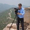 Le journaliste Yvan Côté manipulant une caméra au sommet de la muraille de Chine.
