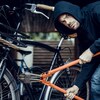 Un voleur utilise une pince géante pour couper le cadenas d'un vélo.