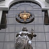 Une statue de Thémis, déesse grecque de la justice, et l'emblème de l'État russe à l'entrée de la Cour suprême de Russie, à Moscou, le 30 novembre 2023. 