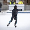 Un garçon qui porte un masque patine à l'extérieur à Toronto.
