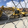 Derrière une clôture métallique, des pelles mécaniques sur le chantier de construction Well Sud au centre-ville de Sherbrooke
