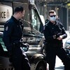 Deux policiers de Vancouver au centre-ville. L'un d'eux porte un masque. 