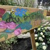 Une pancarte  « Au printemps c'est la fête ». Des abeilles et des fleurs sont représentées. 