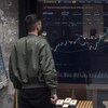 Un homme regarde les cours du Bitcoin devant un bureau de change.