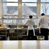 Des étudiants sont en train de cuisiner de dos dans une cuisine d'un centre professionnel. 