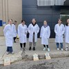 Des étudiantes portent un sarrau et attendent que leurs photos soient prêtes, après une exposition à la lumière du jour. 
