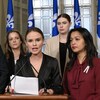 Léa Clermont-Dion, Joël Arseneau, Guylaine Maroist, Laurence Gratton et Ruba Ghazal devant des drapeaux du Québec dans un salon de l'Assemblée nationale.