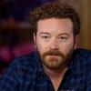 Danny Masterson, assis dans un bar, écoute une question du public.
