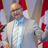 M. Lametti parle devant des drapeaux canadiens.