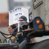 Un homme porte une pancarte du syndicat SCFP.