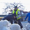 Trois personnes avec des pelles dans un banc de neige