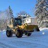 Un tracteur de machinerie lourde effectue une opération de déneigement à Winnipeg durant l'hiver 2022.