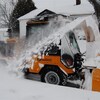 Une déneigeuse à trottoir en action.