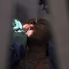 Un dentiste traite une patiente.