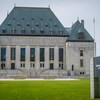 La Cour suprême du Canada vue de l'extérieur, un édifice gris au toit vert.