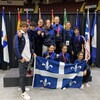 Des athlètes posent avec le drapeau du Québec.