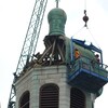 Des travailleurs sur une nacelle au haut d'une église
