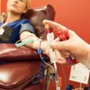 Une femme fait un don de sang. 