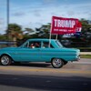 Une bannière pro-Trump flotte de la vitre d'une voiture qui en marche.