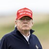 Donald Trump portant une casquette rouge sur laquelle il est écrit : Rendons sa grandeur à l'Amérique.