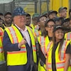 Doug Ford entouré de travailleurs lors de la visite d'une usine pendant la campagne.