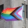 Le drapeau inclusif LGBTQ2S+ flotte dans les airs.