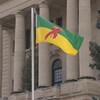 Un drapeau vert, jaune décoré par le ruban rouge, symbole de la lutte contre le sida, flotte devant le palais législatif de la Saskatchewan 