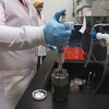 Un chercheur avec des gants dans un laboratoire.
